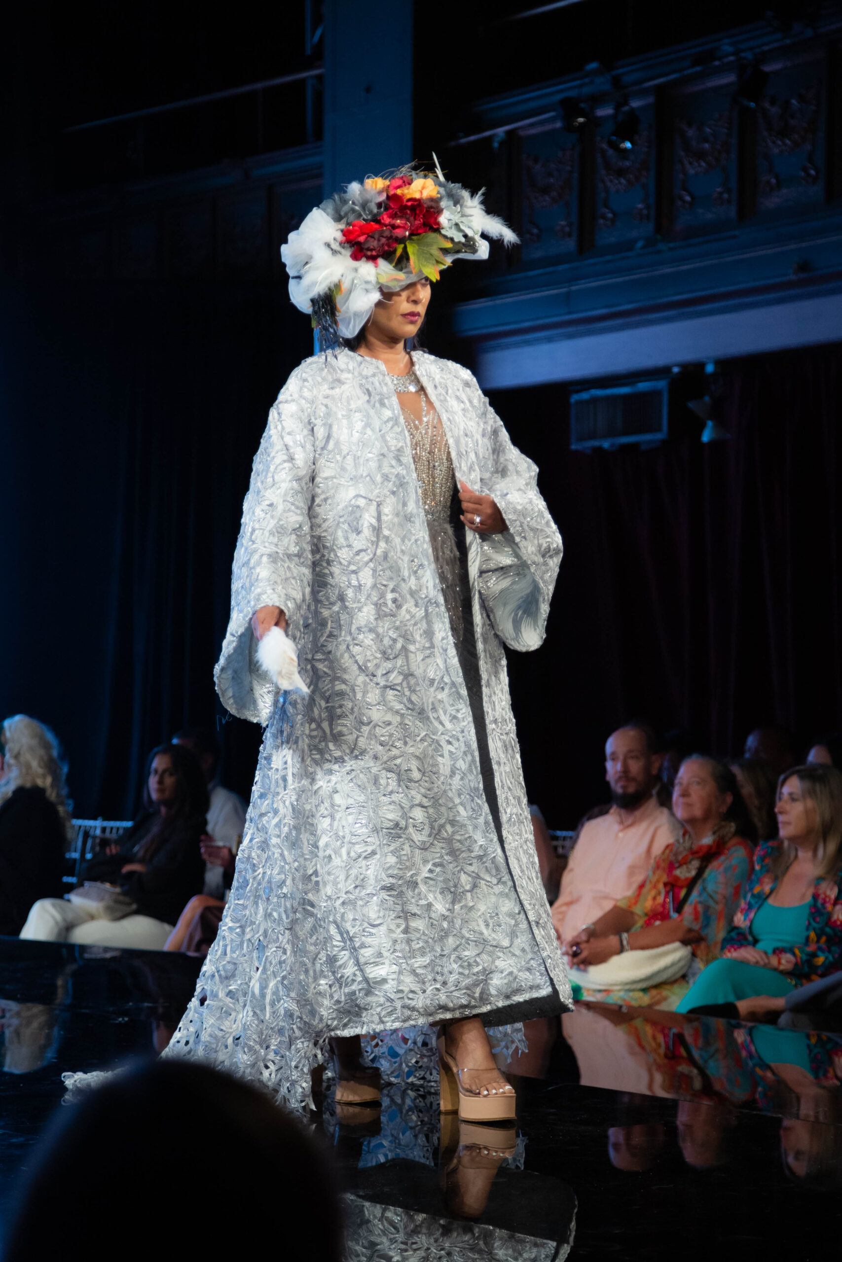 Model in a luxurious silver opera coat by Elfida’s Atelier on the runway at International Heritage Fashion Week, New York.