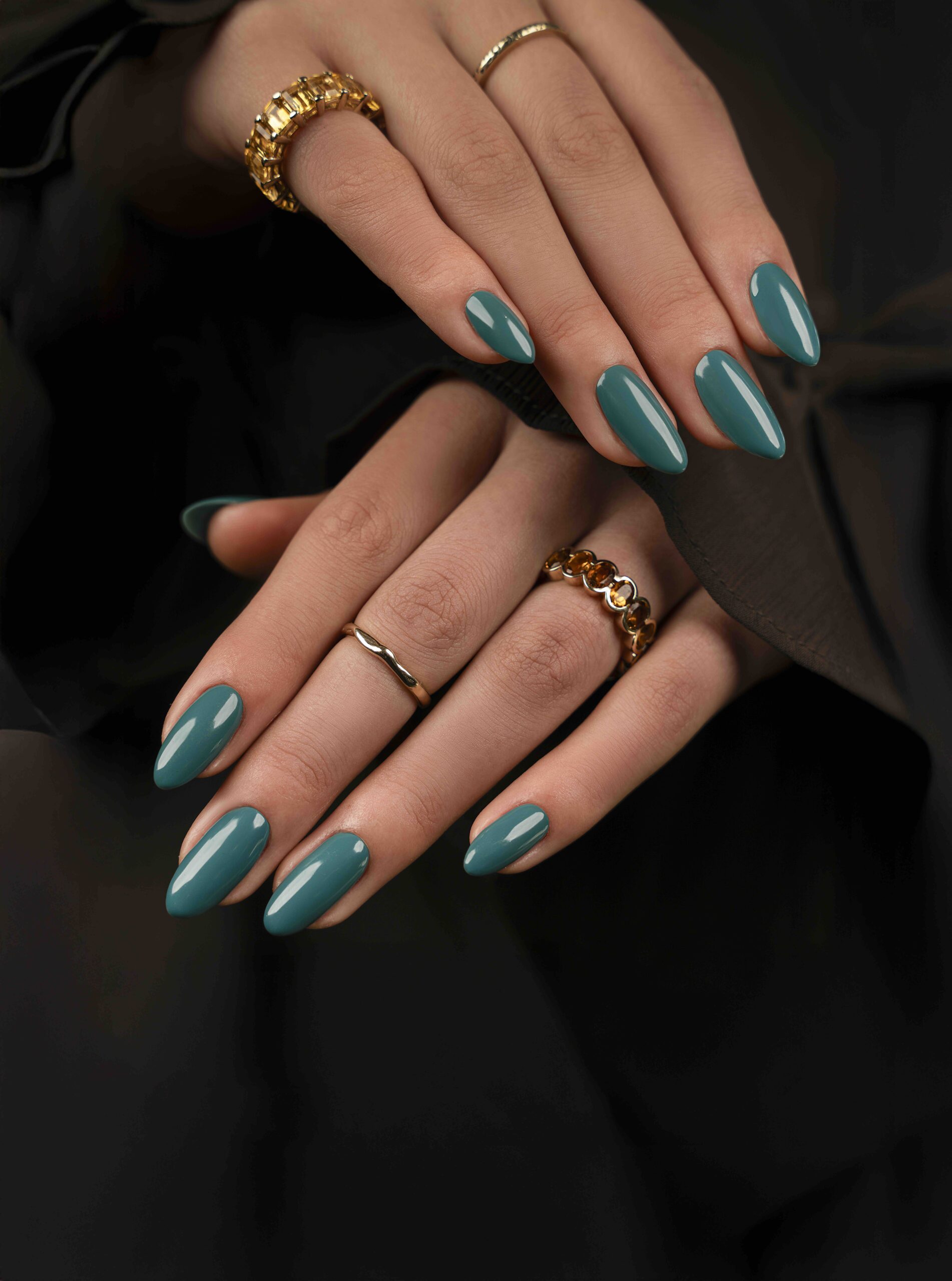 Hands with teal-blue nails showcasing Bio Sculpture’s Sapphire Whisper gel polish — a deep jewel tone inspired by sapphire gemstones.