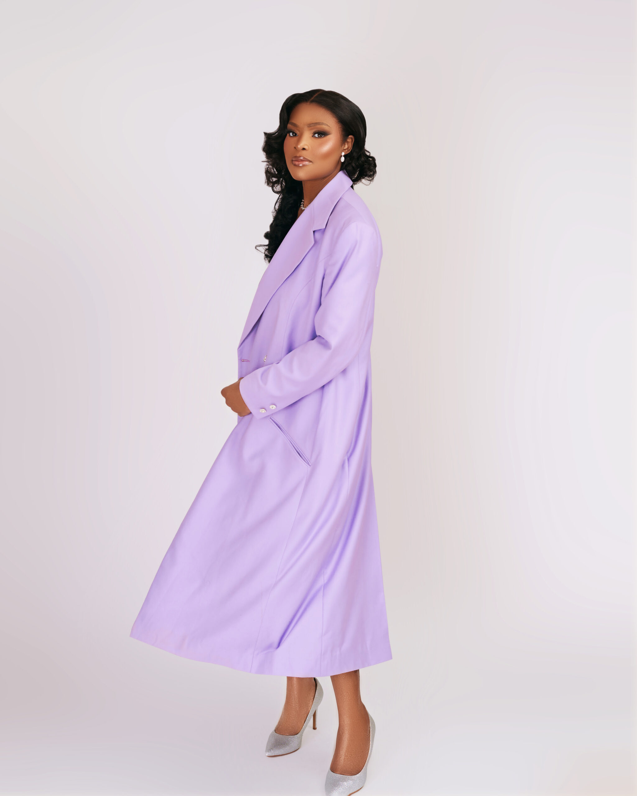Model wearing a lilac coat by OJOYI, designed by Jane Ogbe-Makinwa, modern luxury womenswear