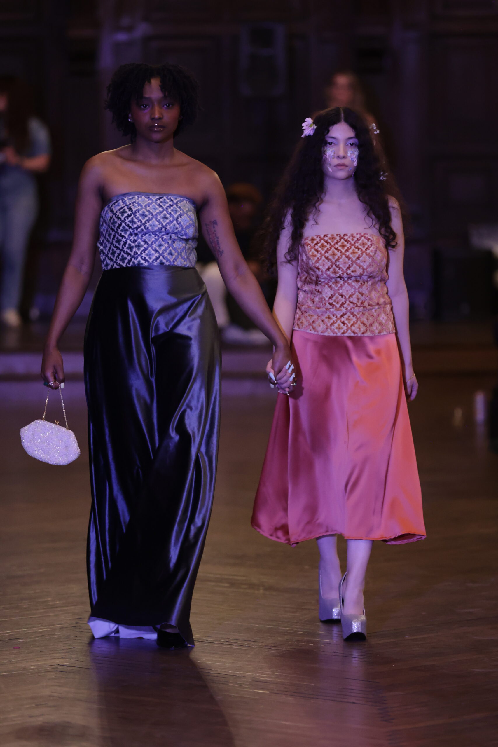 Two models walking hand in hand wearing REHAB New York designs at Break Free NYFW 2026 in New York City