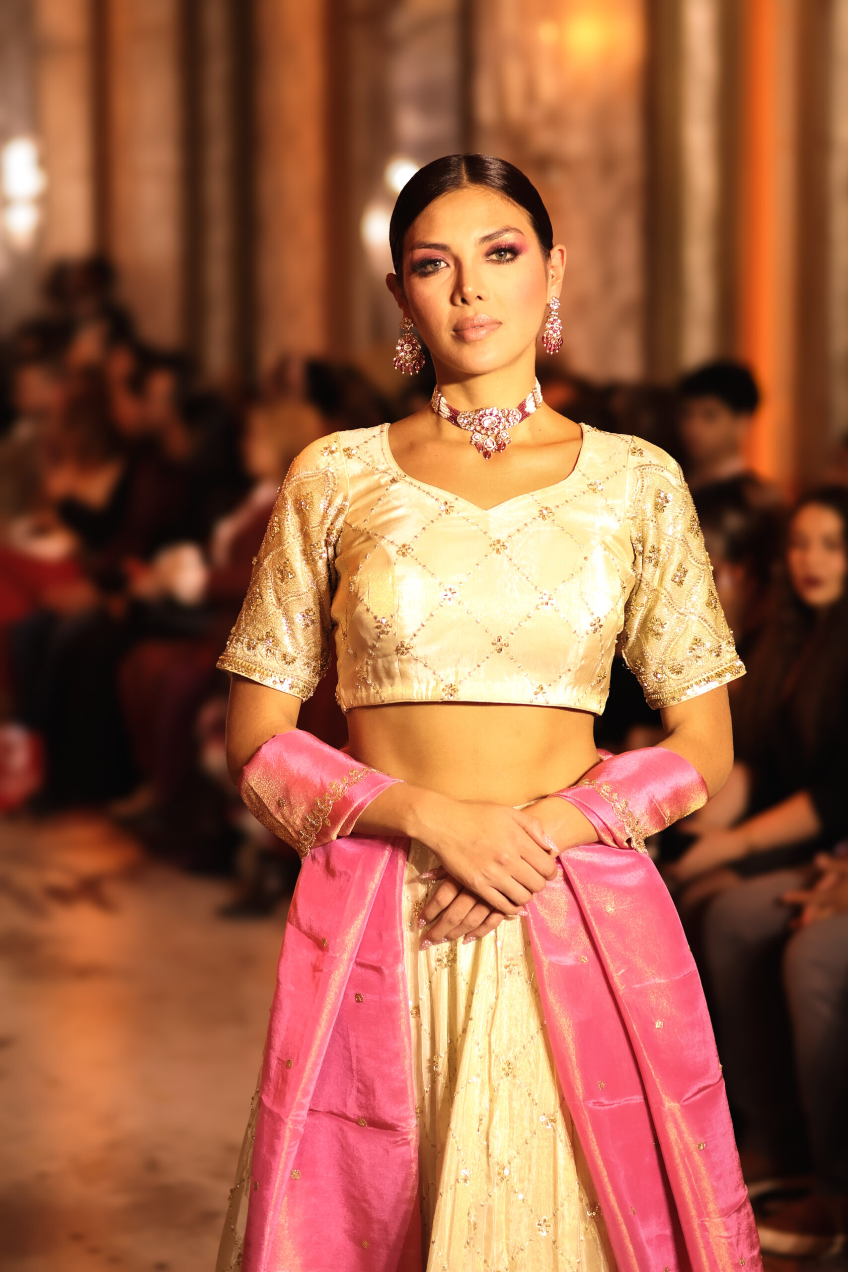 Model walks the runway in a gold lehenga with pink dupatta from MOHIKAS by Archana Soni RASA NOVA collection at Milan Fashion Week FW 2026–2027