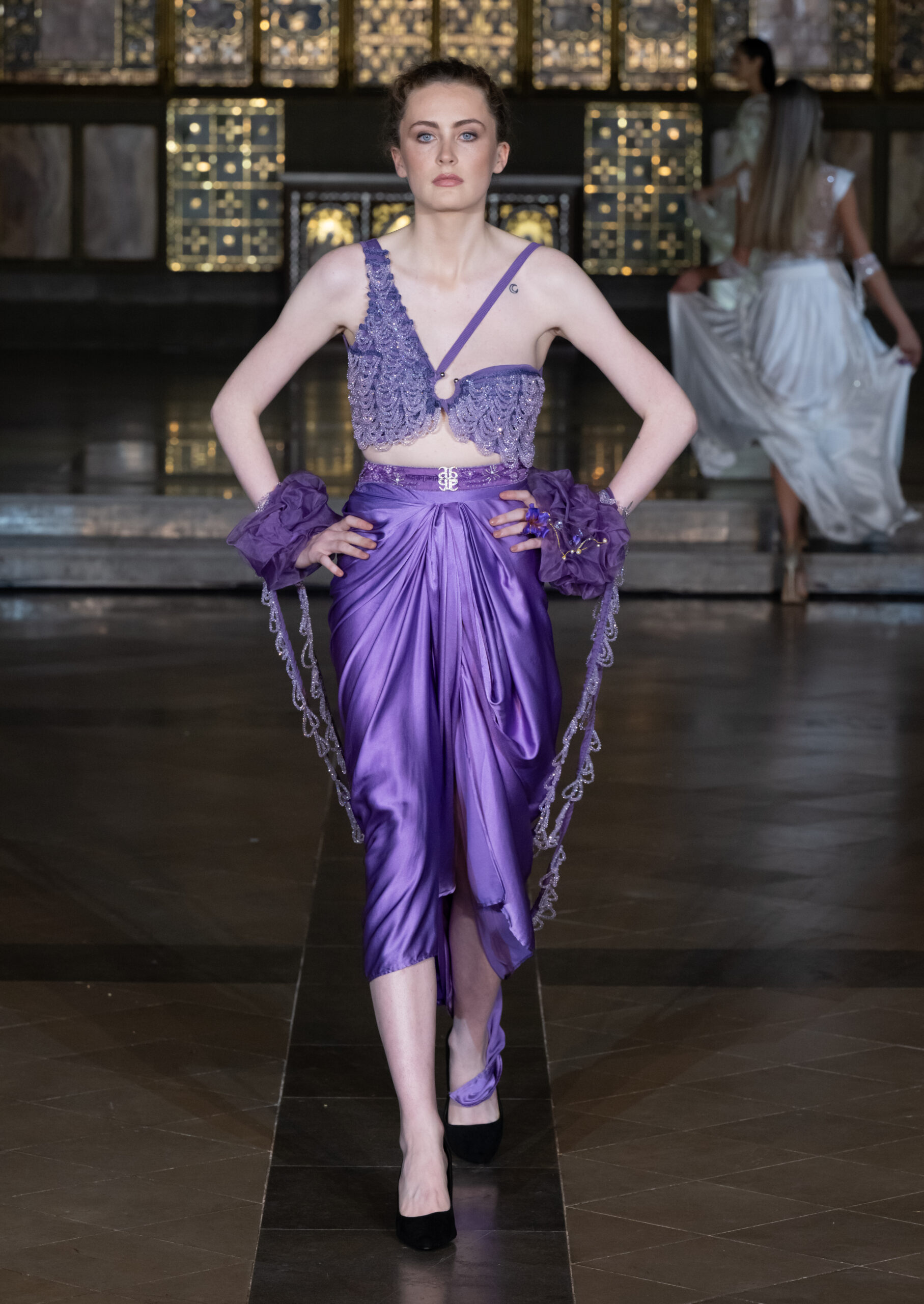 Saanjh by Saloni purple satin draped skirt and embellished lace crop top at London Fashion Week AW2026 — Fashion Week and the City, St John's Church, Hyde Park.