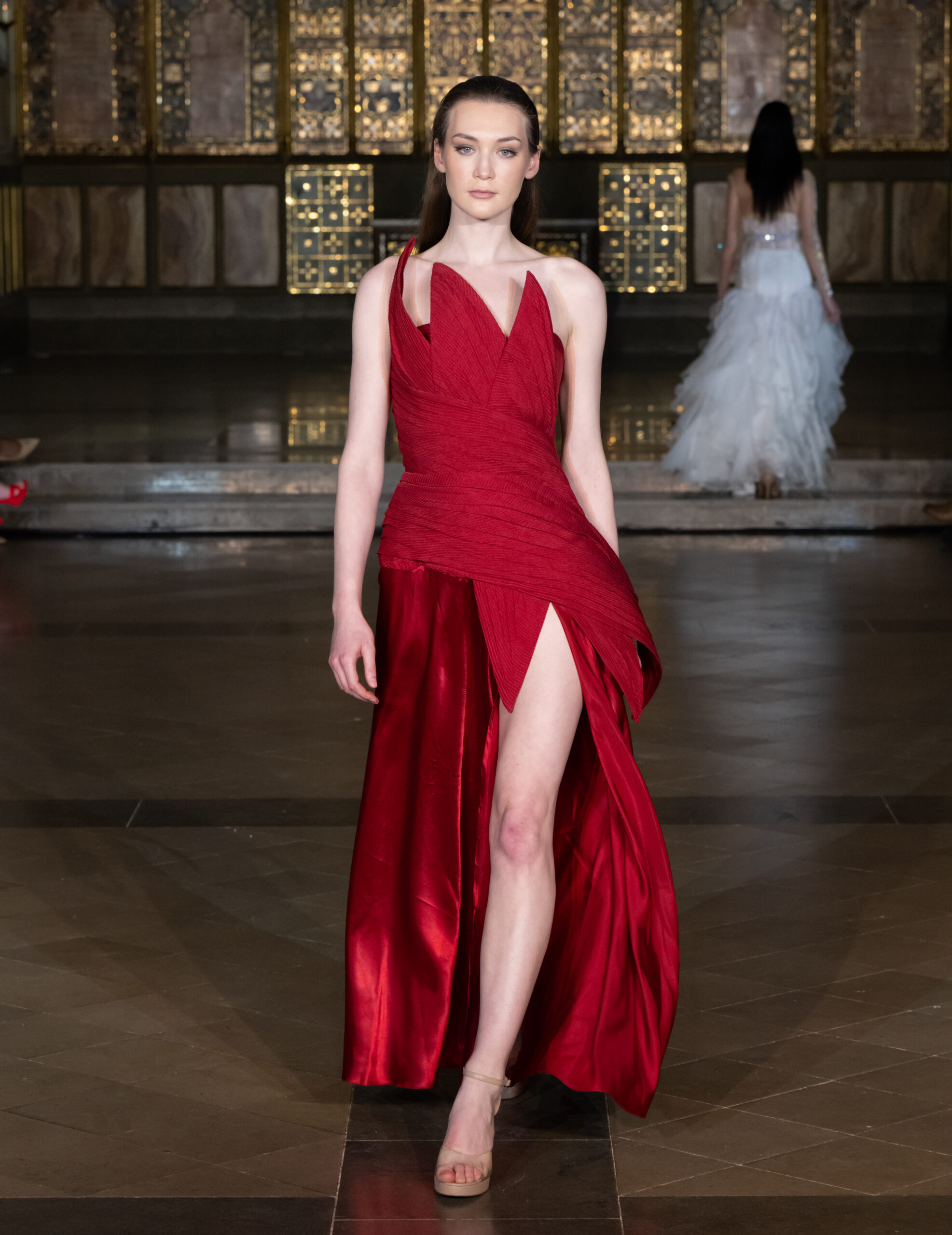 Zavoir by Swarali sculptural red gown with asymmetric neckline and high slit at London Fashion Week AW2026 — Fashion Week and the City, St John's Church, Hyde Park.