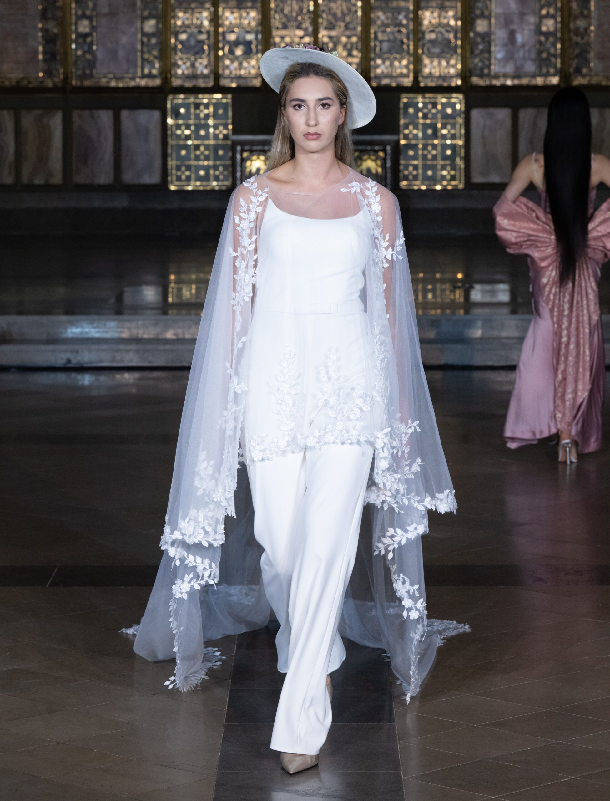 Sheers Bridal Boutique bridal pantsuit with lace cape and hat at London Fashion Week AW2026 — Fashion Week and the City, St John's Church, Hyde Park.